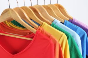 Colorful Clothes On Hangers Against White Background