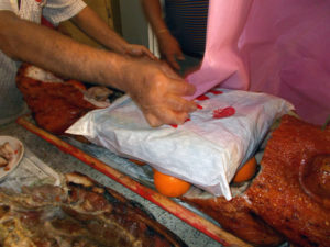 21.12.01 女家切割下燒豬的中間部分，再塞進多粒橙與一套男裝衣褲