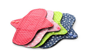 Many cloth menstrual pads on white background. Reusable female h