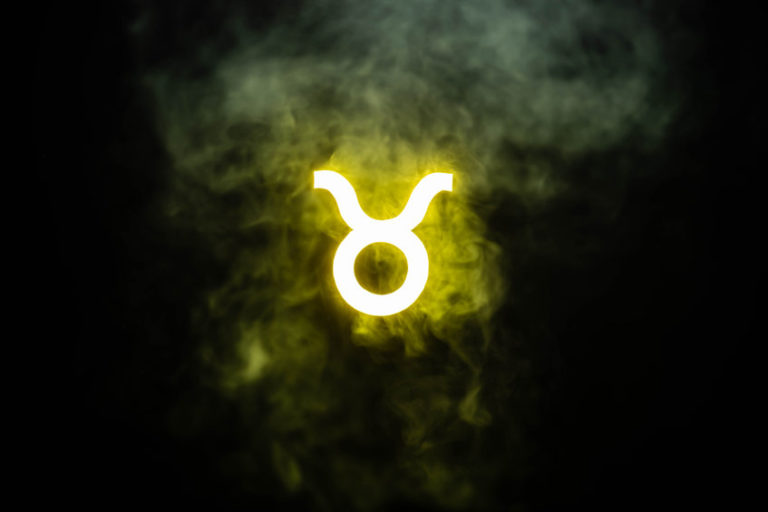 yellow illuminated Taurus zodiac sign with smoke on background