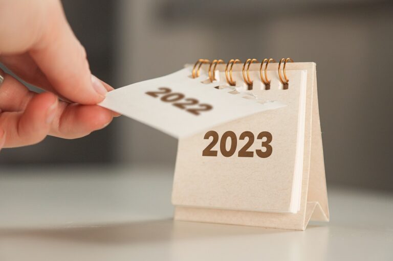 a woman's hand turns over a calendar sheet. year change from 2022 to 2023