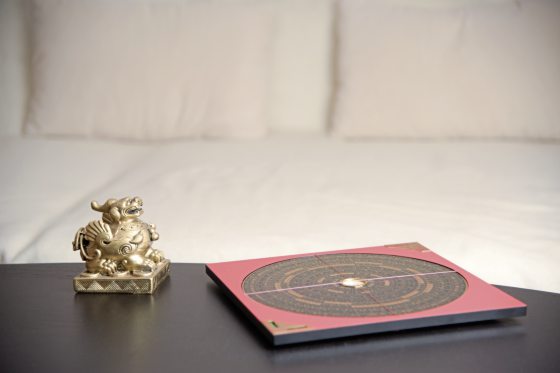 An asian symbol and a Feng Shui compass on a table