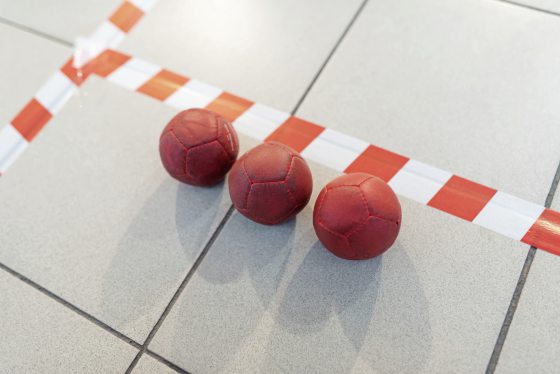 Boccia balls, red, on the field line.