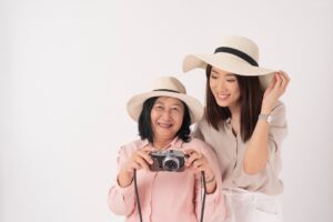 Asian Older Woman And Her Daughter On White Background, Travel Concept